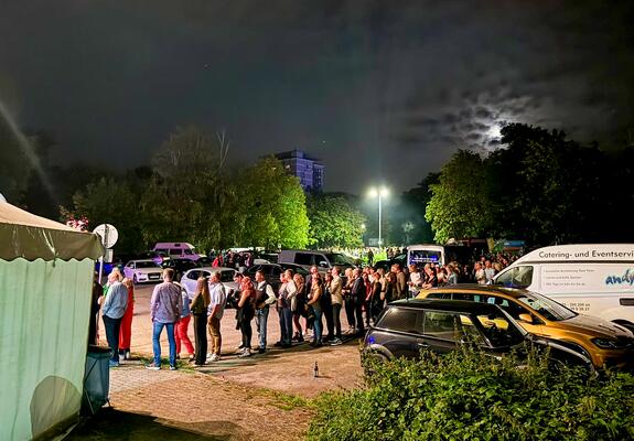 Schlangen vor dem Einlass, die bis zur Sport- und Kongresshalle reichen, ausgelassene und friedliche Feierstimmung im Saal