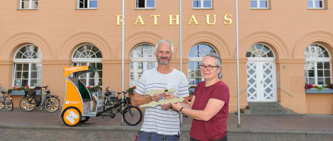 Restauratorin Andrea Grund (r.) aus Krakow am See überreichte die frisch überarbeiteten Zeiger an Frank Hohmann vom ZGM-Hausmeisterservice, Foto: maxpress/iw