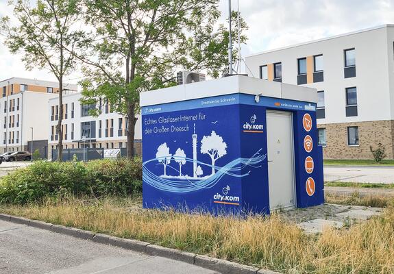 Glasfaser-Knotenpunkt der Stadtwerke Schwerin erhielt im Juli ein Graffiti und ist der neue Hingucker in der Anne-Frank-Straße. Mit einem lokalen Bezug aus der Spraydose schmücken Fernsehturm und leuchtende Glasfasern die technische Station im Wohngebiet