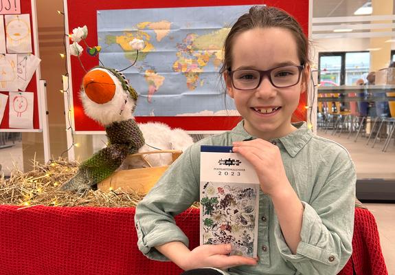 Emilie zeigt stolz den Spendenkalender für „Ärzte ohne Grenzen“, an dem sie mit vielen Kindern des Frei-Zeit-Horts gearbeitet hat, Foto: Kita gGmbH/Luke Pirnke