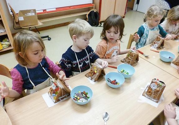 Lieselotte, Domenic, Hans und Mia Ella packen in der Kita Rappelkiste Päckchen für andere Kinder