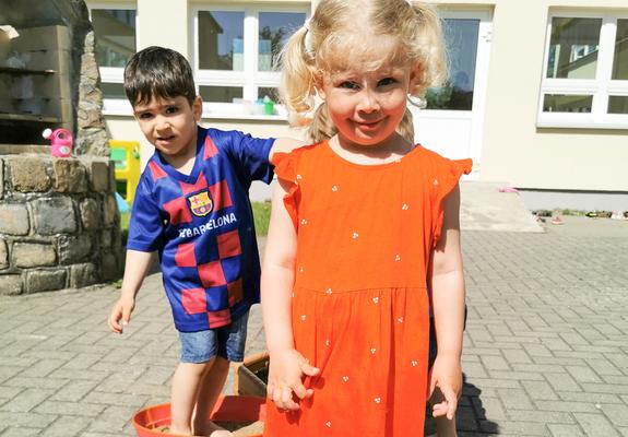Die Schuhe stehen am Rand, nackte Füße tapsen über den Hof der Kita Sonnenschein auf dem Großen Dreesch. Der zweijährige Torenik und die kleine Petra meistern gerade den Barfußpfad mit anderen Krippenkindern.