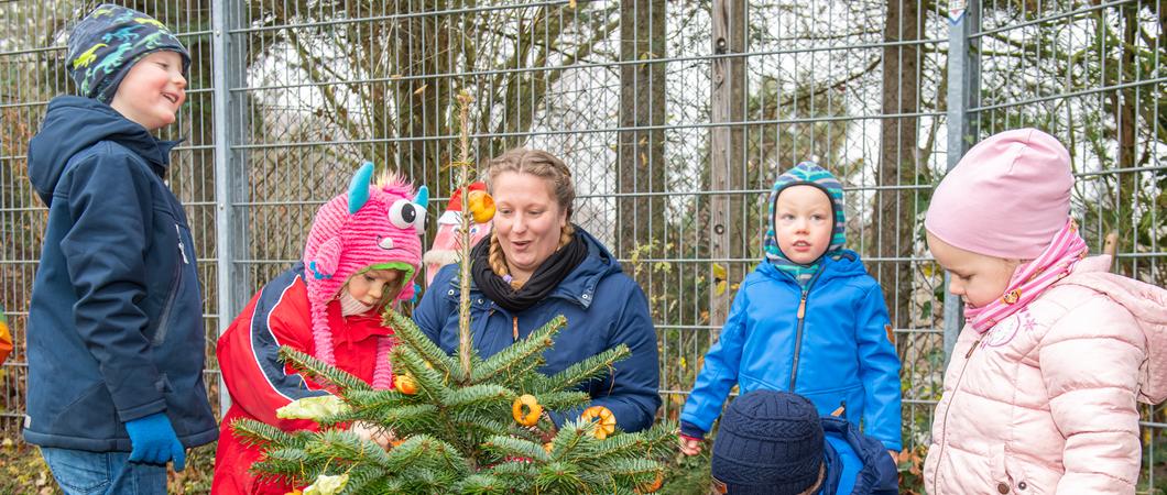 Damit die tierischen Besucher der Naturkita am Lewenberg kleine Leckereien finden, wird die neu eingepflanzte Tanne von Erzieherin Conny Thäger und den Kindern liebevoll mit Obst geschmückt