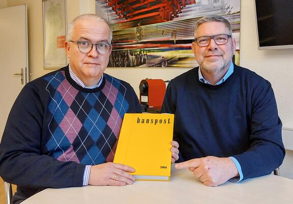 V.l.: Franzel Simon, Regionalgeschäftsführer Nord und Daniel Dellmann, Klinikgeschäftsführer lesen in der hauspost von 2004 über die Übernahme durch Helios