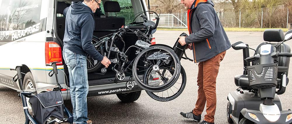 V.l.: Fabio Tricomi und Andreas Meier beim Verladen eines Aktivrollstuhls mit Handbike, eines E-Scooters sowie des Premiumrollators Topro Pegasus