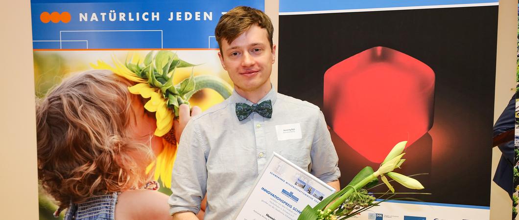 Henning Rüß von der Hochschule Wismar mit der Urkunde für seine Arbeit