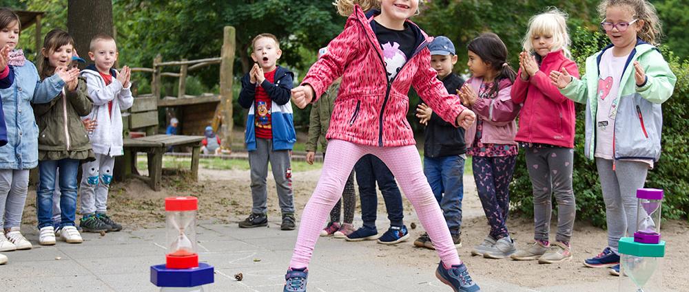 Im Jahresprojekt „Rad der Zeit“ probieren die Kids der Kita Sonnenschein unter anderem altbewährte Spiele aus. Elena und ihre Freunde hüpfen Hinkelkästchen
