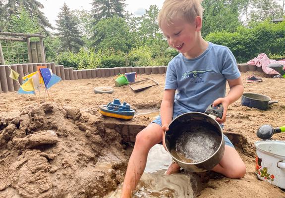 Louis steckt schon mittendrin im Matsch, während Matteo und Ella noch im Sand buddeln und die Kuhle für die Modderparty in der „Naturkita“ erst vorbereiten.