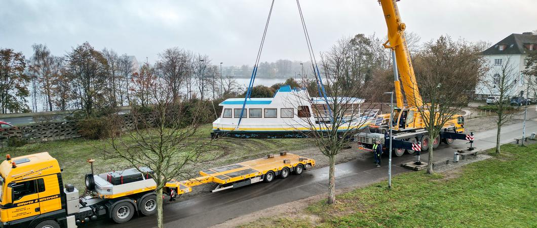 Auch der „Pfaffenteichkreuzer“ muss ab und zu zum „TÜV“. So wurde er kürzlich per Kran auf einen Tieflader gehoben und zum Betriebshof des Nahverkehrs gebracht.