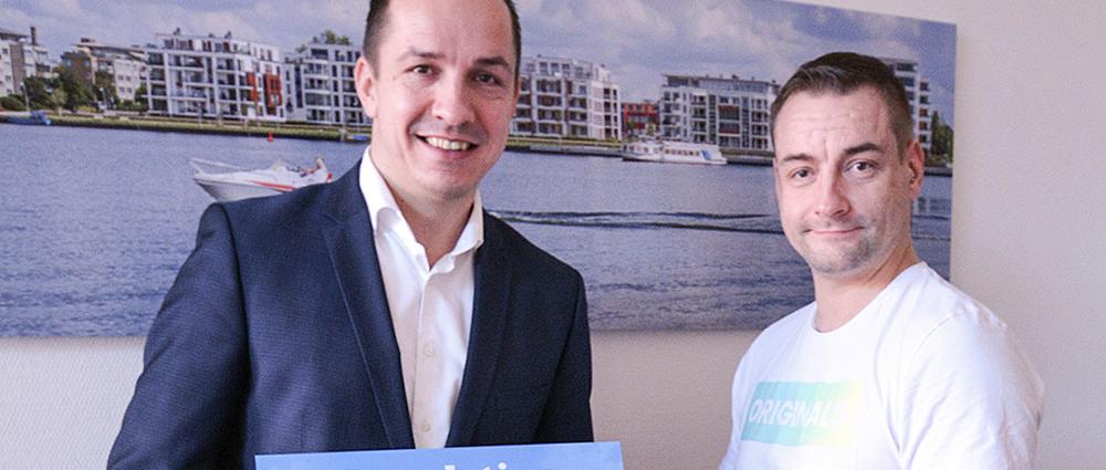V.l.: Michael Jastram (Sparkasse) überraschte Felix Zech mit dem Gewinn eines Mobile-Paketes
