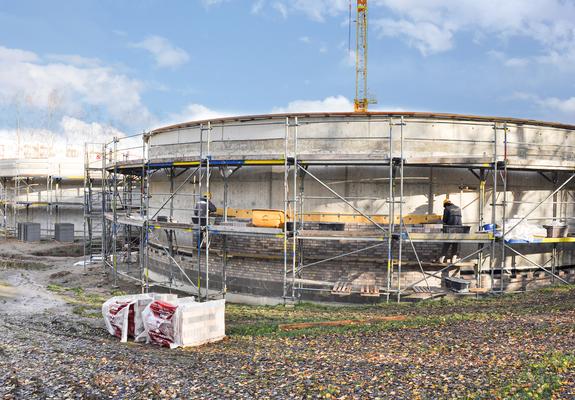 Die Verblendung der gedämmten Fassade mit Klinkern hat bereits begonnen